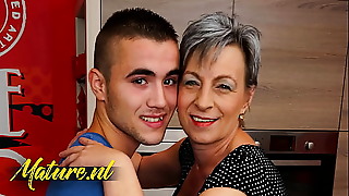 Stepson gets cozy with an elderly busty woman, indulging in taboo pleasure and breaking societal norms.